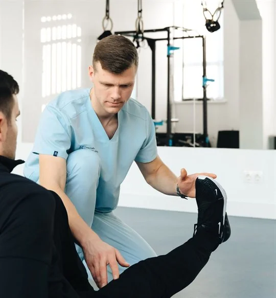 Physiotherapist guiding a patient through a leg exercise
